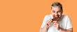 © Prostock-studio - Man sweet tooth happily bites chocolate, on yellow background, empty space
