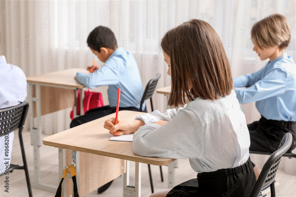 Cute girl doing exercises during lesson in classroom