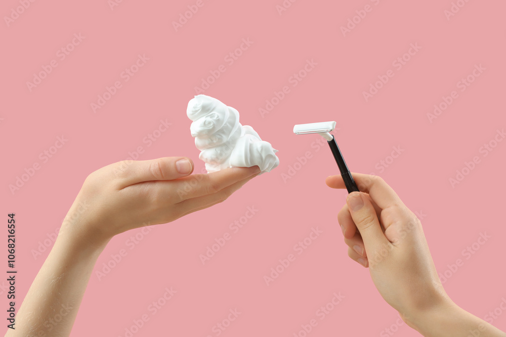 Female hands with razor and foam on pink background