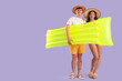 © Pixel-Shot - Happy young couple with inflatable mattress on lilac background