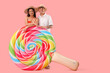 © Pixel-Shot - Happy young couple with inflatable mattress in shape of candy on pink background