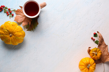 Canvas Print - Fresh pumpkins with autumn leaves, rose hip berries and cup of tea on light blue background