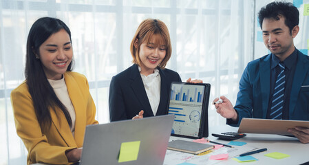 Teamwork Makes the Dream Work: Collaborative business professionals analyze data on laptops and tablets, showcasing synergy and innovative problem-solving in a modern office setting.  