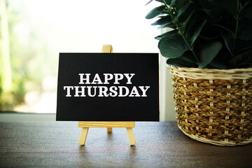 Wall Mural - happy thursday text on paper card with ealsel on wooden background