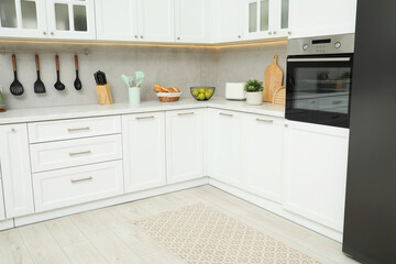 Canvas Print - Stylish soft rug on wooden floor in kitchen