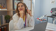 © Krakenimages.com - Attractive blonde woman in a vet clinic talking on the phone, surrounded by medical equipment and books.