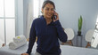 © Krakenimages.com - Young woman talking on phone in spa setting with towels and decorative plant in the background