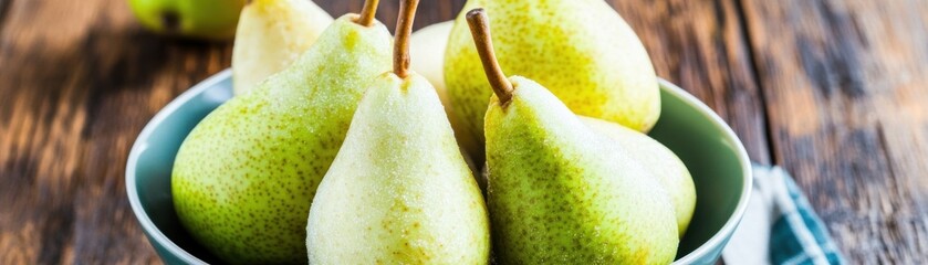 Poster - A bowl filled with fresh, green pears on a wooden table.