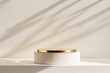 © Dmitriy - White cylindrical podium with gold top, illuminated by soft sunlight