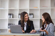 © wichayada - Professional Business Women Collaborating and Consulting with Colleagues in a Modern Office Environment
