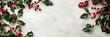 © Diliara - Christmas background with real holly leaves and red berries on a light background covered in snow with copy space.