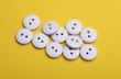 © splitov27 - White Wooden buttons on a yellow background close up