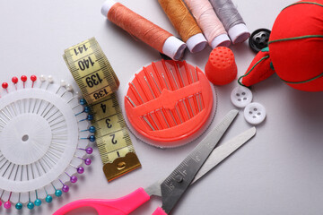 Tailor sewing accessories on gray background.