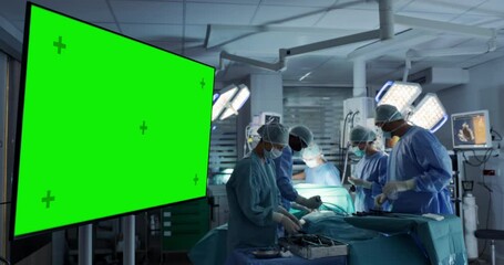 Leinwandbilder - Green Screen Mock Up Display in the Operating Room with Medical Team Performing a Surgery on a Patient in the Background, Using Specialized Tools, Looking at Digital Screens with Health Information