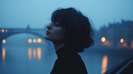 Wall Mural - A serene atmosphere envelops a young woman as she gazes thoughtfully by the foggy river, soft reflections shimmering in the twilight