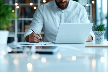 Poster - A man is immersed in work on his laptop in a spacious and bright modern office environment. This highlights concentration and contemporary workplace design.