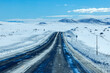 © Tetra Images - Empty interstate crossing snow covered landscape