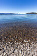 © Tetra Images - Rocky beach and calm lake on sunny day