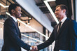 © BullRun - Sprightly multiethnic men entrepreneurs making agreement at office