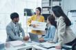 © Kritdanai - Business Meeting: A diverse team of professionals collaborates in a modern office setting. The woman in the center presents a colorful diagram to her colleagues.