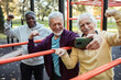 © Marko Geber - Senior friends taking a selfie after a group workout at an outdoor park