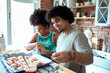 © Davor - Friends cooking homemade pizza together in the kitchen