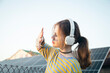 © sav_an_dreas - A girl listens to music on headphones against the backdrop of solar panels.