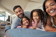 © Rido - Portrait of smiling multiethnic family lying down on bed together