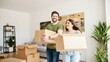 © velikiyzayats - Happy Couple Moving into New Home with Boxes, Green Plants, and Comfortable Living Room Furniture