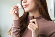 © Pormezz - close-up view person test smelling aroma essential oil in the bottle for diffuser