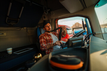 Professional truck driver with a heat and in plaid shirt fastening seat belt before starting a new trip.