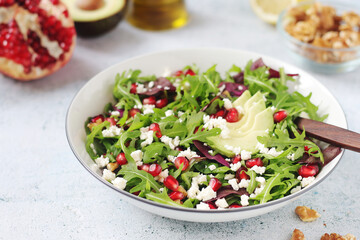 Wall Mural - A plate with green rocket salad with pomegranate and avocado