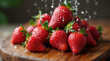 © Анатолий - Handful of strawberries gently dropped onto wooden surface in bright kitchen