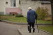 © Юрий Горид - a lonely elderly woman with a cane walks down the street and carries a bag
