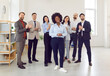 © Studio Romantic - Happy company employees congratulating happy female colleague on job well done applauding standing in office. Business people and group of staff clapping to young african american woman.