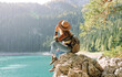 © maxbelchenko - Female traveler enjoying the view of Lake among mountains. Hiking with backpack. Active lifestyle.