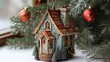© owen - A charming decorative house ornament nestled among festive evergreen branches and red ornaments, evoking a warm holiday spirit.