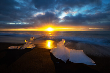 Wall Mural - Diamond beach in Vatnajokull, southern Iceland. Sunrise shot of chunks of ice on the black sand, that have been deposited on the beach from the Jokulsarlon glacier lagoon.