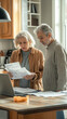 © ЮРИЙ ПОЗДНИКОВ - Worried senior couple reading documents and using laptop at home