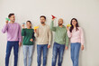 © Studio Romantic - Team of happy smiling people flying paper planes together. Cheerful male and female friends in casual sweatshirts and jeans standing by white wall holding colorful airplanes. Dreaming, success concept
