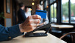 © StockLab - A man holding a blue credit card in his hand for payment