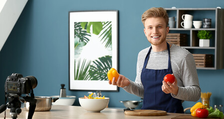 Wall Mural - Young male food blogger recording video in kitchen