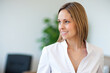 © Minerva Studio - Businesswoman smiling and looking away in office environment