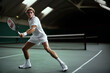 © OneLoveOnePhoto - Man wearing a tennis white outfit playing on a court.