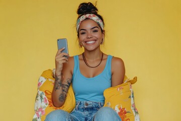Aufkleber - A woman sits on a couch, holding a cell phone and looking at the screen