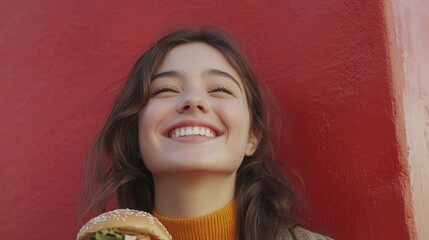 Aufkleber - A woman is standing in front of a bright red wall, holding a sandwich