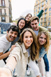 © Xavier Lorenzo - Young group of happy people having fun together outdoors. Multicultural student friends taking selfie portrait together while enjoying travel vacation. Youth community and friendship concept.
