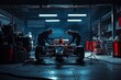 © Sergej Gerasimov - Manager supervision of pit crew repairing formula one race car in dimly lit garage