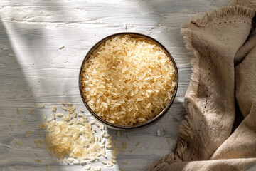 Canvas Print - bowl of raw rice on white sunny rustic kitchen table