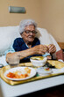 © ADDICTIVE STOCK - Elderly Woman Enjoying a Meal in a Cozy Residence Setting
